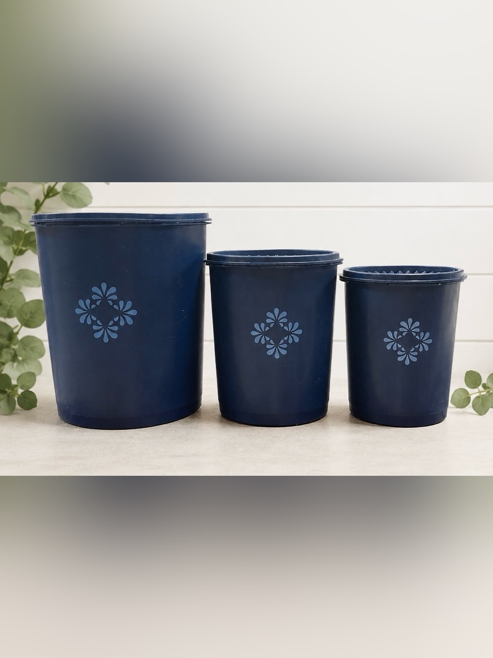 vintage dark blue Tupperware Servalier nesting canisters with a floral starburst